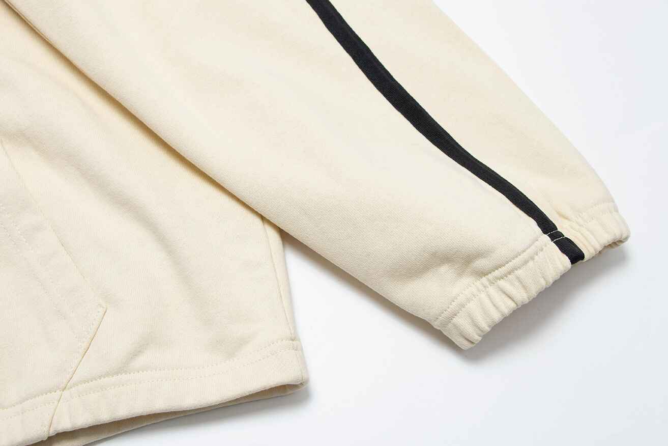 Light-colored hoodie with black stripe detail on sleeve, casual men's apparel latest cheap clothing options, stylish and affordable for everyday wear, soft fabric and comfortable fit.