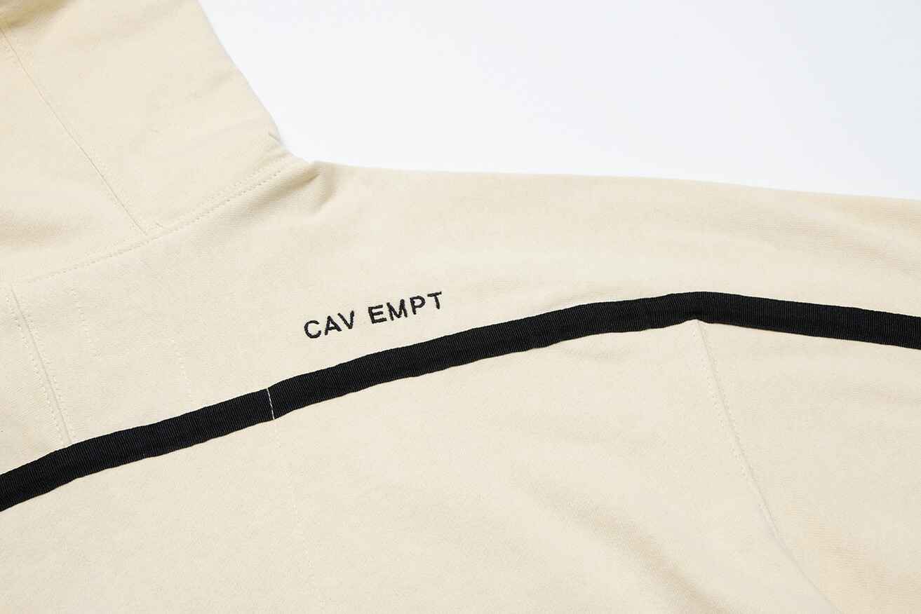 CAV EMPT logo on off-white sweatshirt with black horizontal stripe, casual streetwear style, minimalist design.