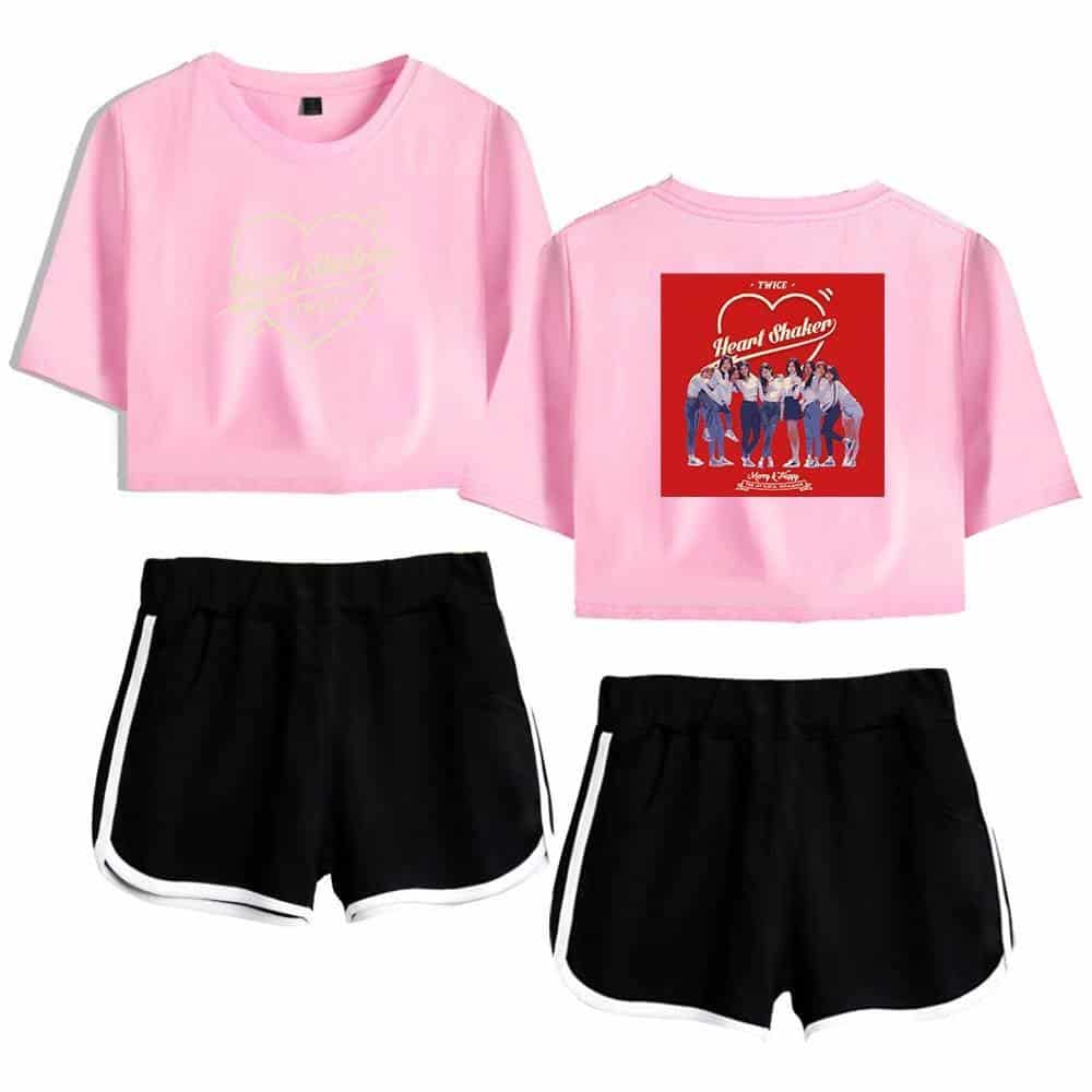 Pink crop top with graphic print and black athletic shorts with white trim, casual trendy outfit.